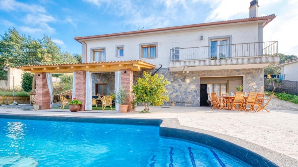 une villa avec une piscine en face d'une maison dans l'établissement Costacabana - Villa Liliana, à Vidreres