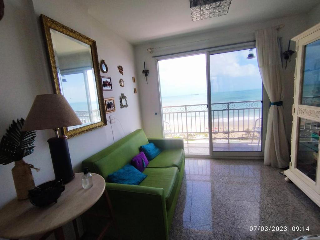 a living room with a green couch and a table at apartamento som do mar. in Fortaleza
