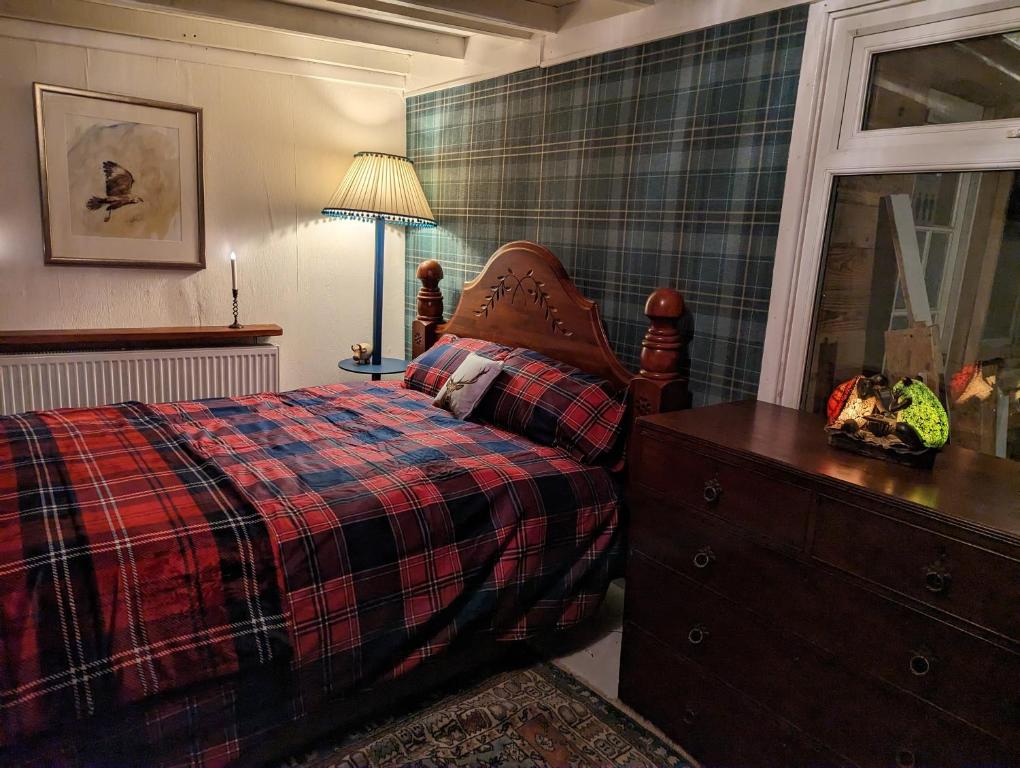 a bedroom with a bed and a dresser and a window at The Old Hay Barn in Bursledon