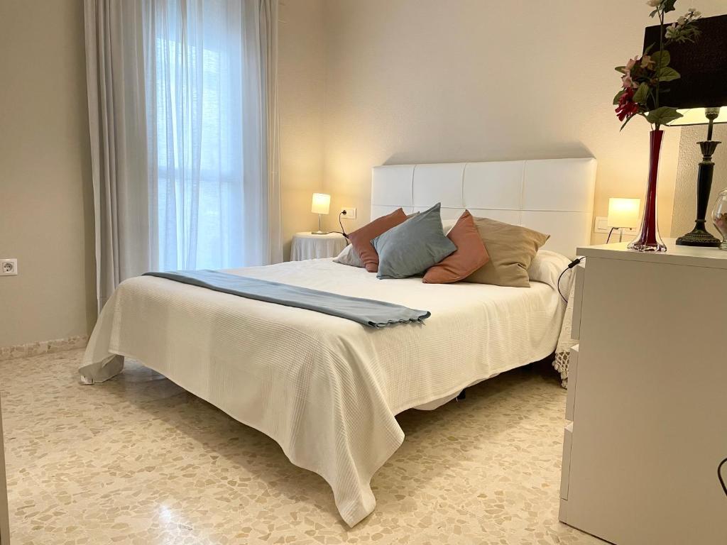 a bedroom with a large white bed with pillows at Apartamento Antón Gómez in Lucena