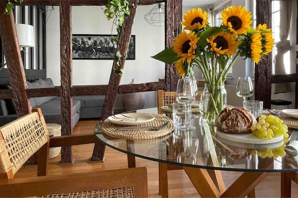 - une table à manger avec un vase de tournesols dans l'établissement Appartement 2 chambres au cœur de Strasbourg, à Strasbourg