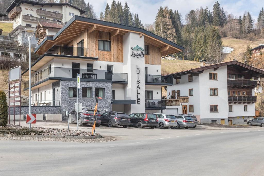 a large white building with cars parked in a parking lot at Luisalle Top 6 in Auffach