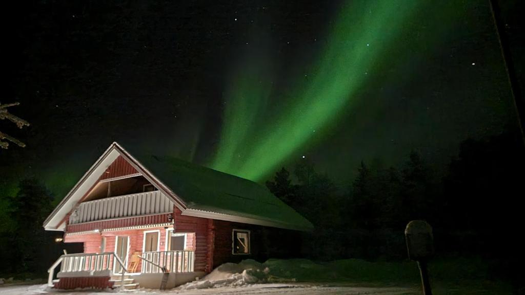 una casa con la aurora en el cielo en Tunturihuvila III, en Vuontisjärvi
