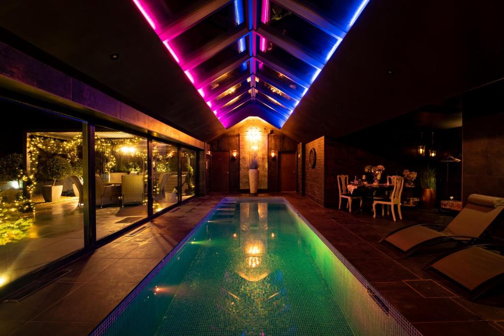 a swimming pool in the middle of a house at night at Black Barn Spa Swim & Stay in Great Yarmouth