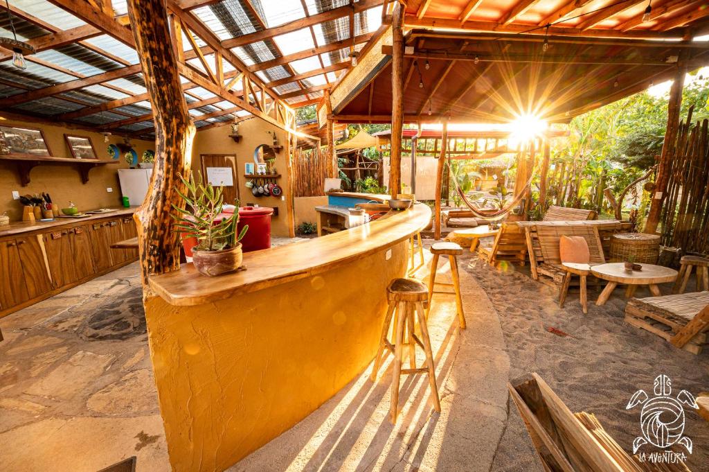 波波尤的住宿－Casa La Aventura Guasacate - Popoyo，餐厅内的酒吧配有桌椅