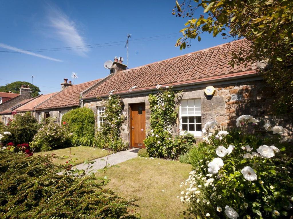 ガレインにあるGreylag Cottageの茶色の扉と庭のあるレンガ造りの家