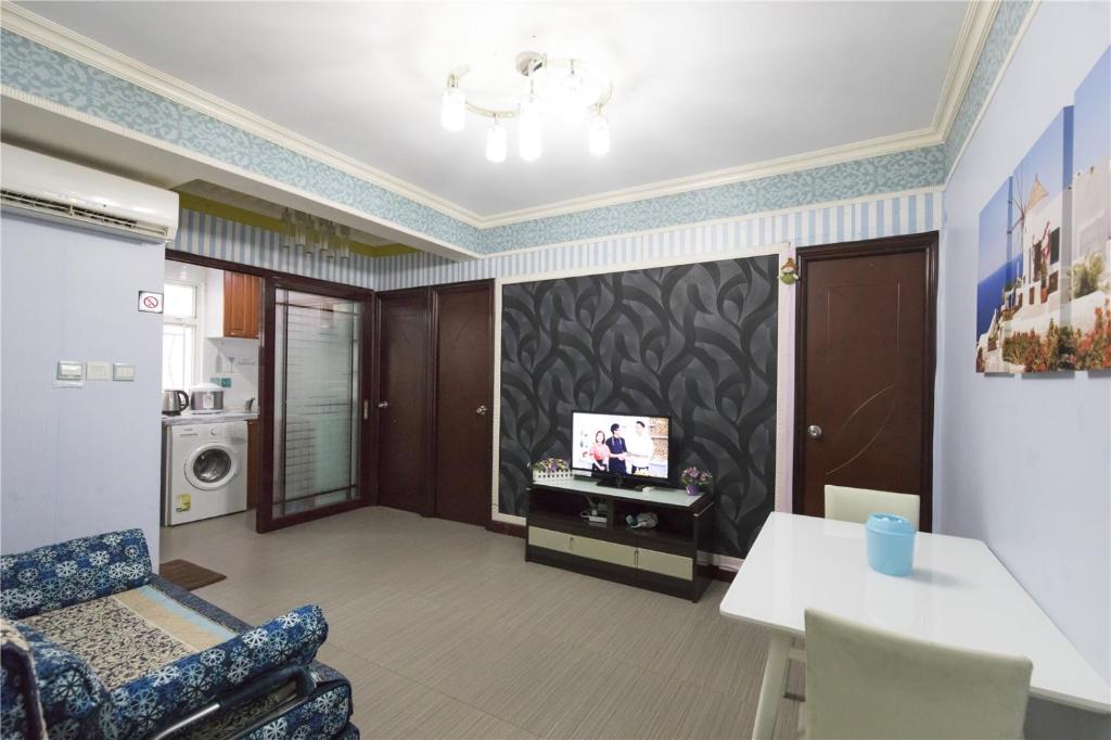 3room charming apt,8pax في هونغ كونغ: غرفة معيشة مع تلفزيون على الحائط
