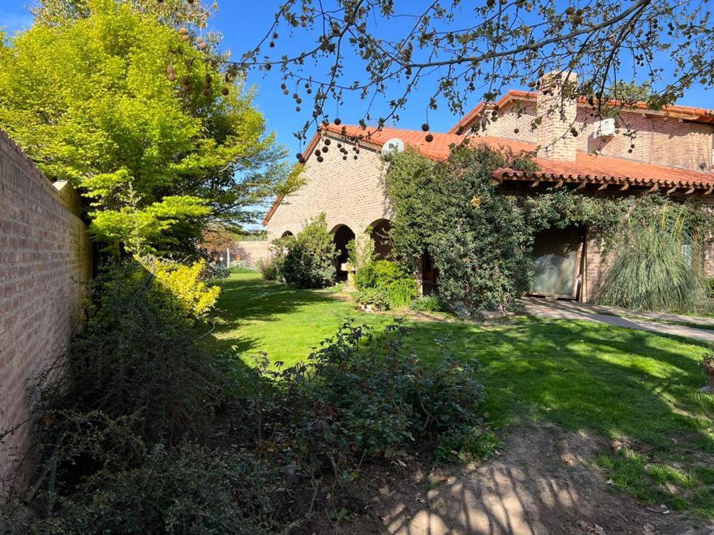 una casa antigua con un patio con césped verde en Departamento Barrio Gamma en Neuquén