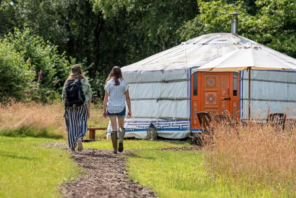 dos mujeres caminando por un camino hacia una yurta en Gilfach Gower Farm Luxury Yurt with Hot Tub en Ammanford