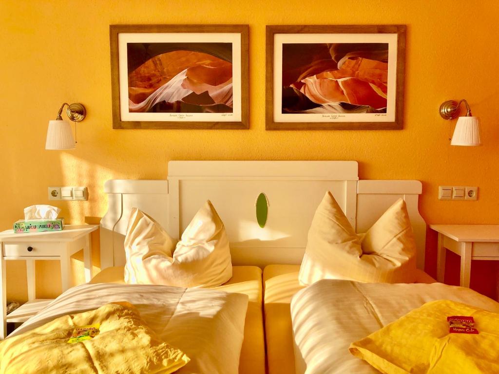 a hotel room with two beds and two pictures on the wall at Haus am Kurpark in Schömberg