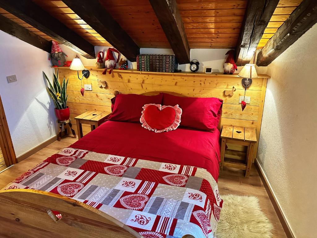 1 dormitorio con 1 cama con colcha roja en Meizon - La Montagna, Pila, Crevacol, Aosta e Valpelline, en Gignod