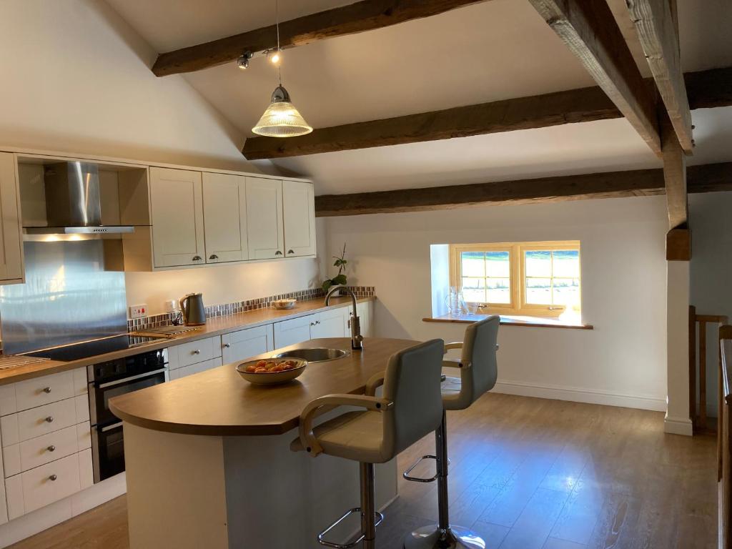 a kitchen with a table and chairs in a room at 2 Malt Kiln Cottages in Grizebeck