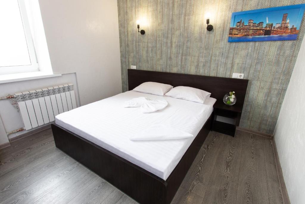 Schlafzimmer mit einem Bett mit weißer Bettwäsche und Kissen in der Unterkunft Апартаменты на Гиршмана 4 in Kharkov