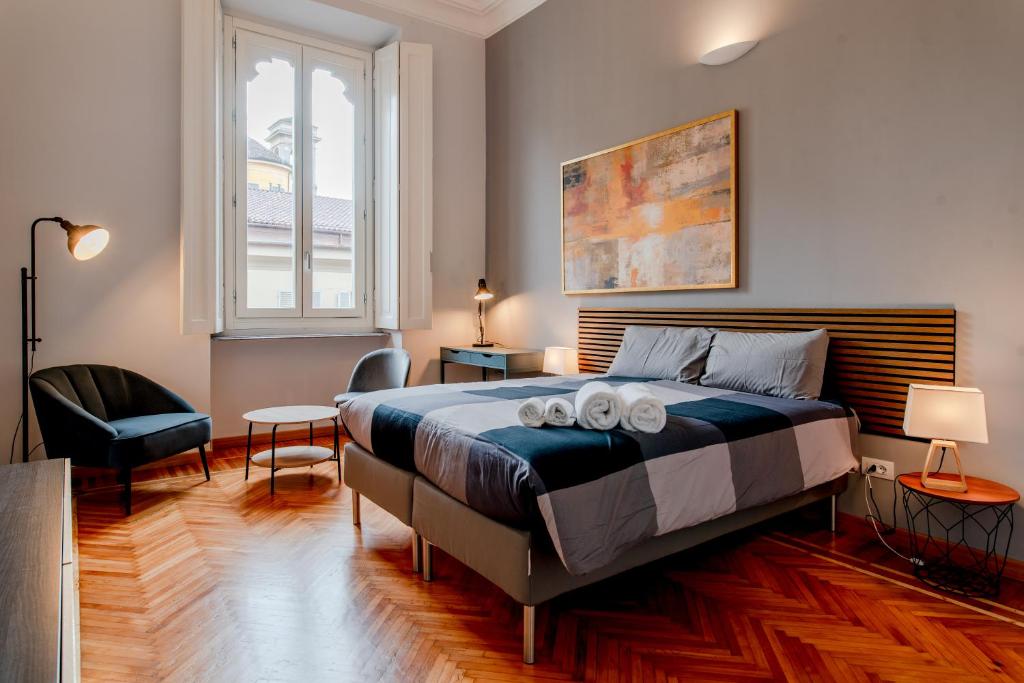 um quarto com uma cama, uma cadeira e uma janela em Oddino 3 - 4 Rooms em Turim