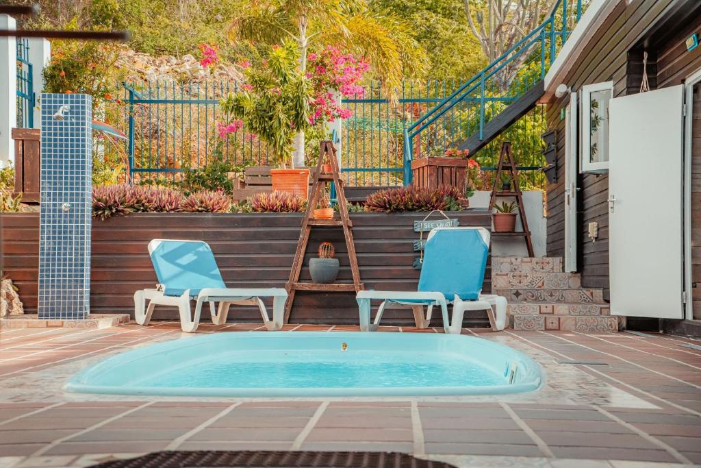 Un patio con dos sillas y una piscina. en Westpunt Beach Apartments, en Willemstad