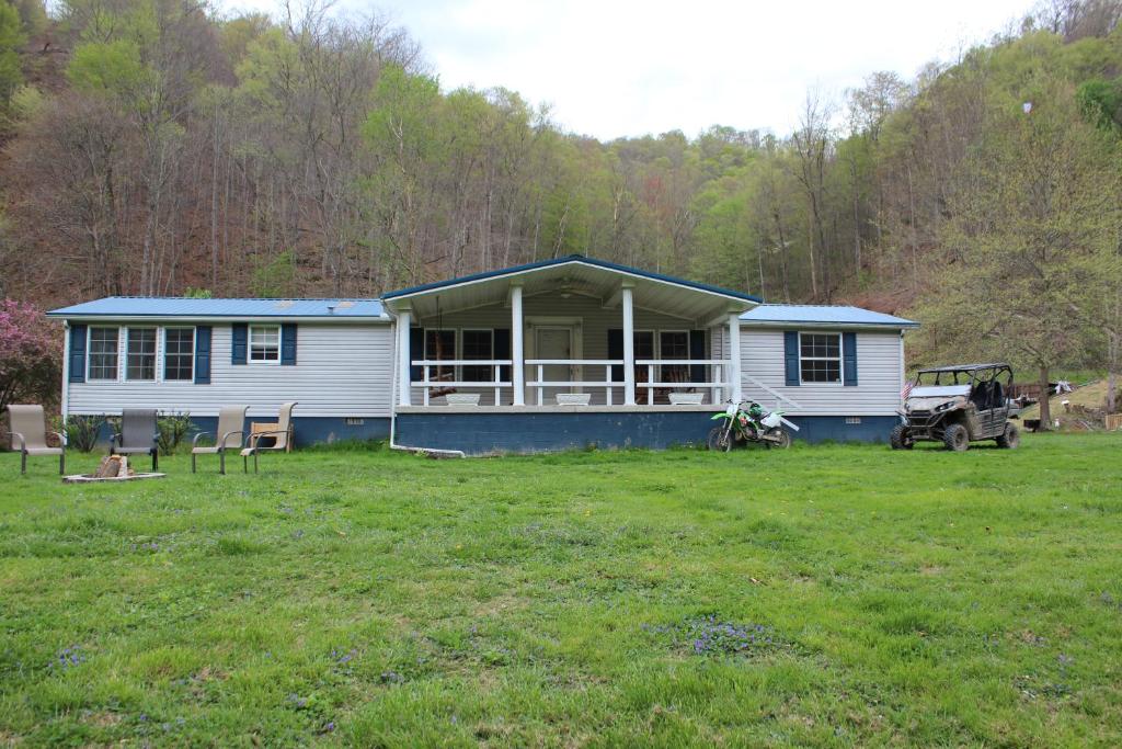 a blue house in a field with a yard at Forest Hills ATV Resort in Forest Hills