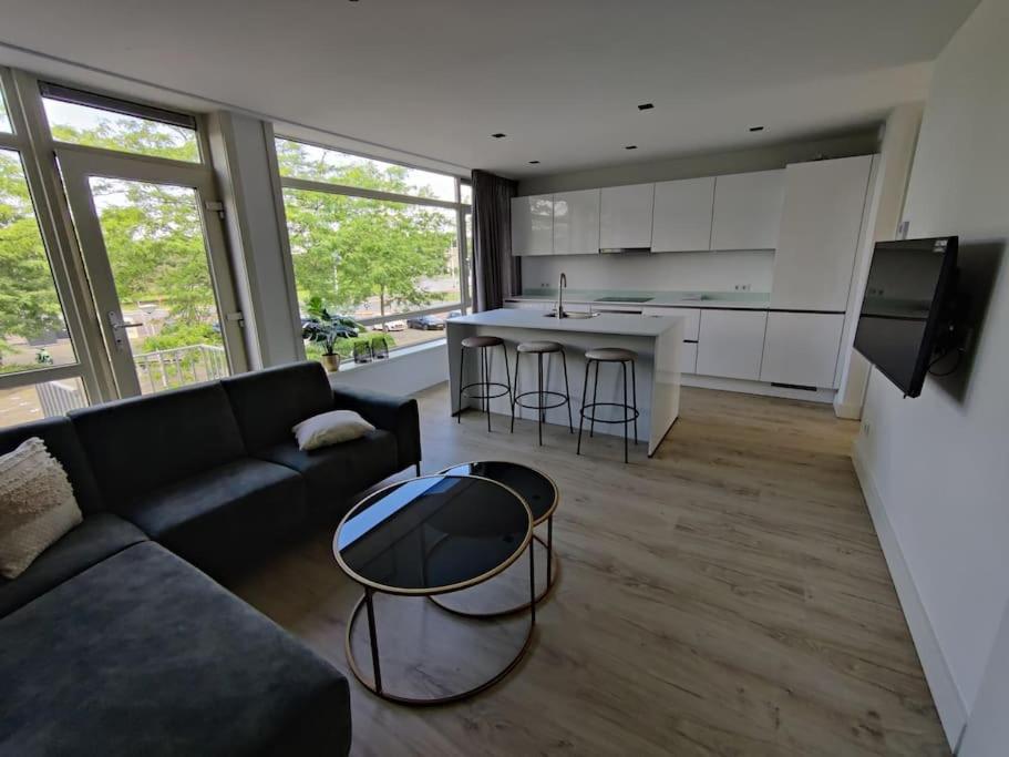 uma sala de estar com um sofá e uma mesa em K50169 Modern apartment near the center and free parking em Eindhoven