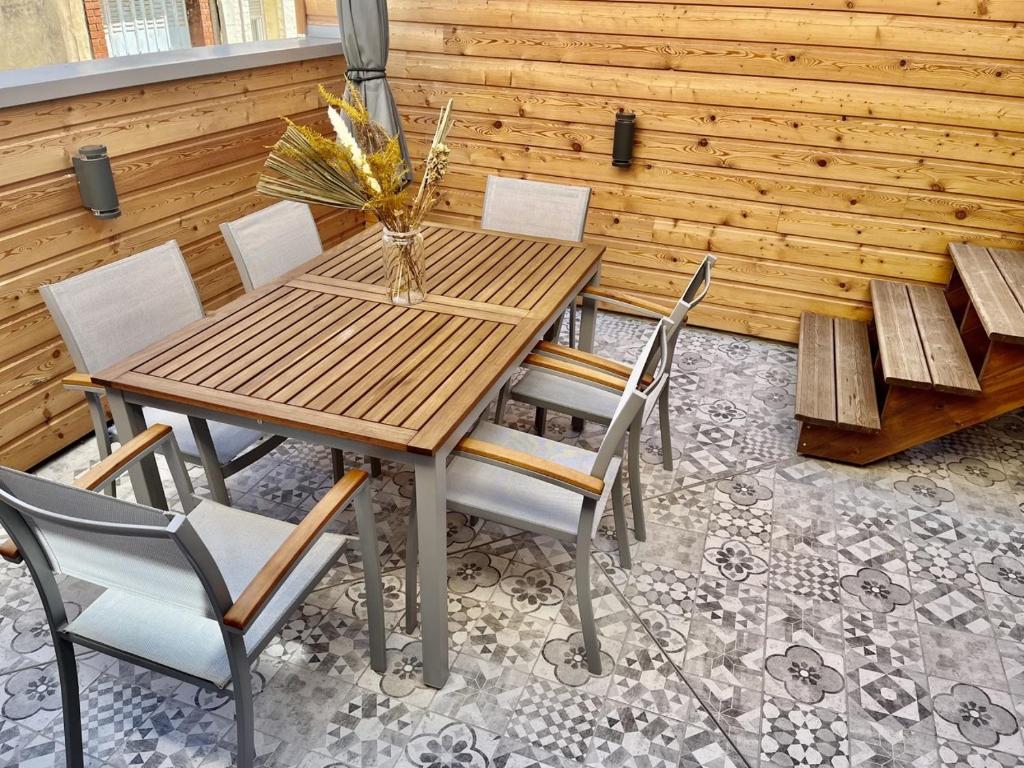 een houten tafel en stoelen op een patio bij Au coeur du vignoble (Verzenay) in Verzenay