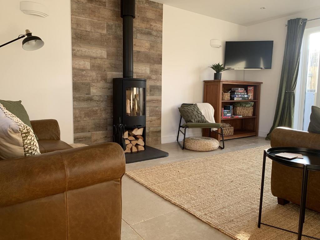 a living room with a couch and a fire place at Whitebridge Cottage in Swansea