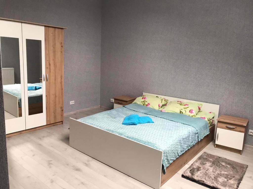 1 dormitorio con 1 cama con manta azul en Катерина en Chynadiyovo