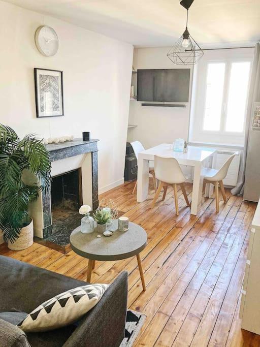 a living room with a fireplace and a table and chairs at Appart/Loft hyper centre POISSY, RER : 2min à pied in Poissy