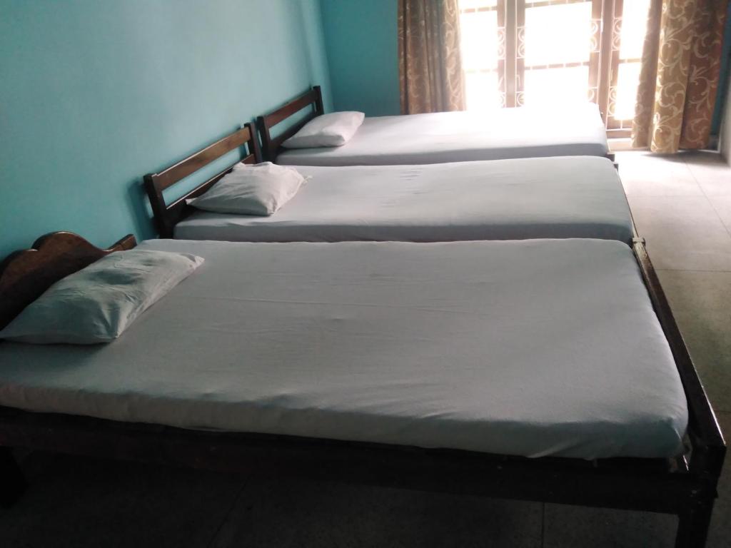 a group of three beds in a room at Access Villa in Nuwara Eliya