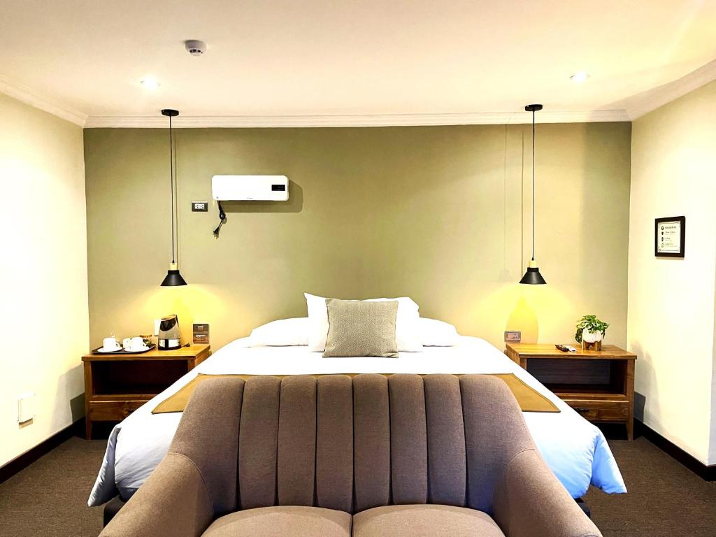 a bedroom with a large bed and two lights at CASA MONTES PARDO in Cusco