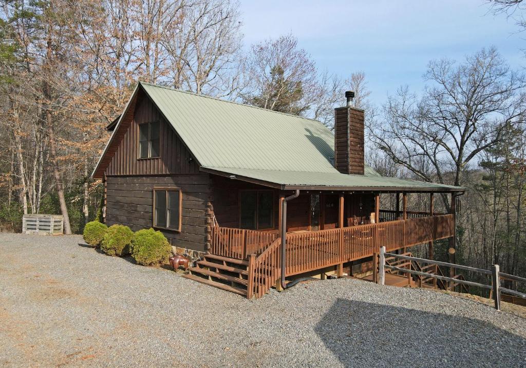 a large wooden house with a green roof at Bucking Bison - Pet friendly, mountain view, hot tub, game room, fire pit and more! in Mineral Bluff