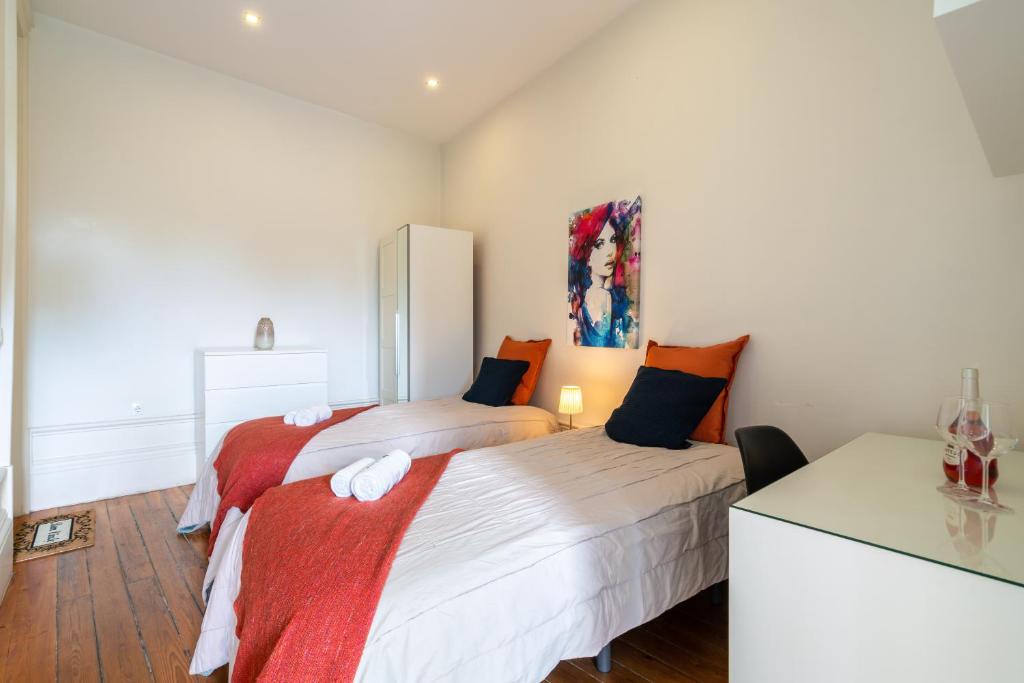 a bedroom with two beds with orange and white at Sweet Bright Flats - City Center in Porto