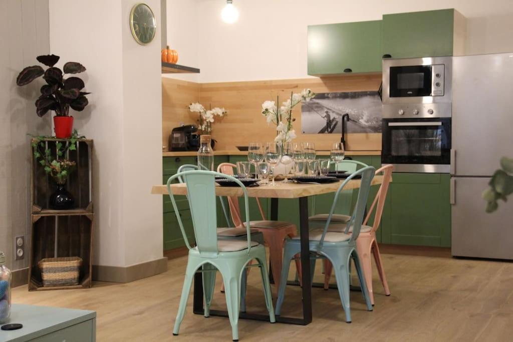 eine Küche mit Tisch und Stühlen und einem Kühlschrank in der Unterkunft Chez Franck et Gisele in LʼIsle-sur-la-Sorgue