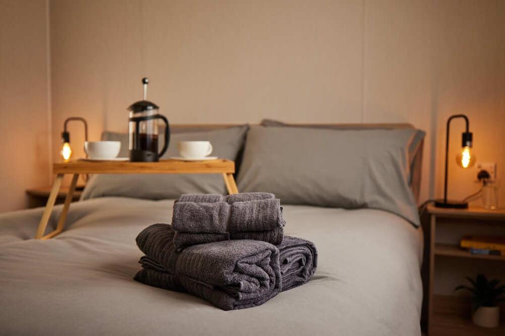 ein Bett mit Handtüchern darüber und einem Tisch in der Unterkunft Nirvana Coastal Retreat Holiday Home in Cayton