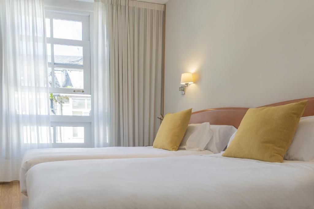 A bed or beds in a room at Hostal ALBA Lugo