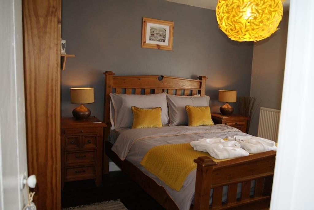 a bedroom with a large bed with yellow pillows at Top Floor at Cantref House in Brecon