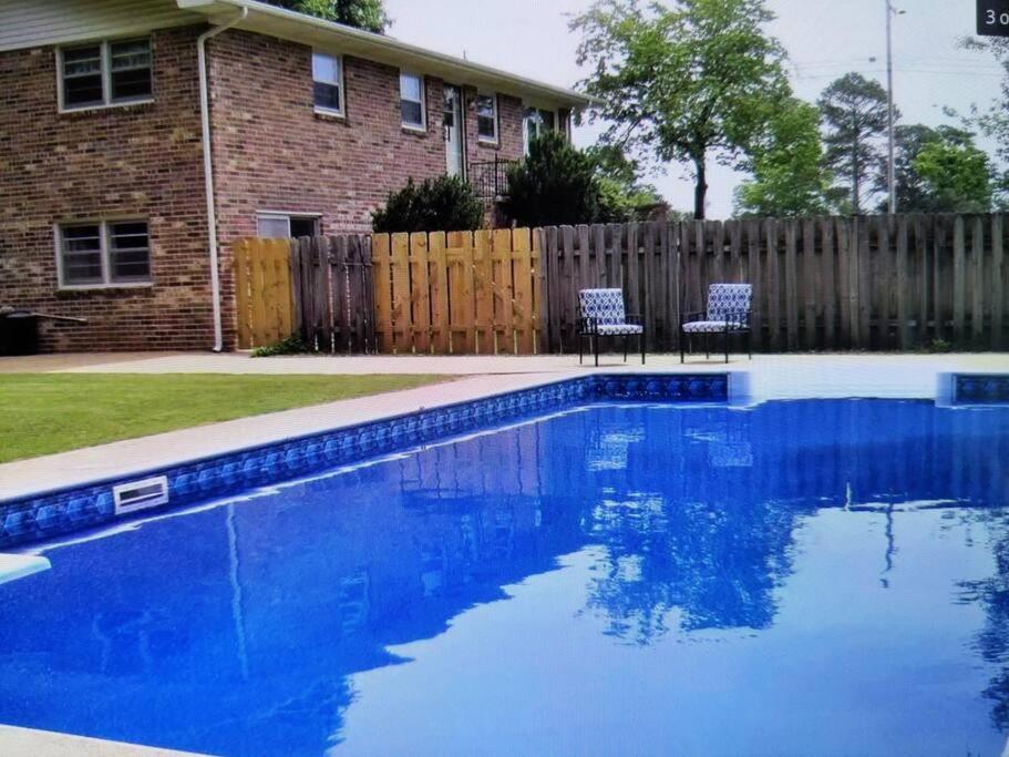 - une piscine avec 2 chaises en face d'une maison dans l'établissement s1. Beautiful home in Historic Scottsboro, à Scottsboro