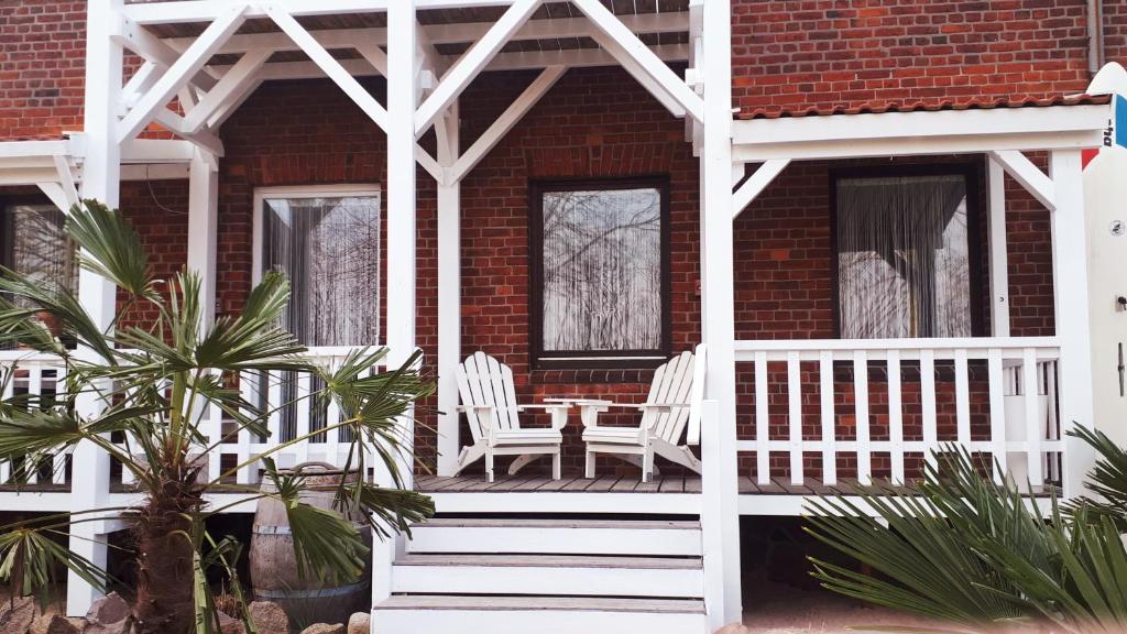 eine Veranda mit zwei Stühlen und einem Tisch darauf in der Unterkunft Strandfeeling in Dahme