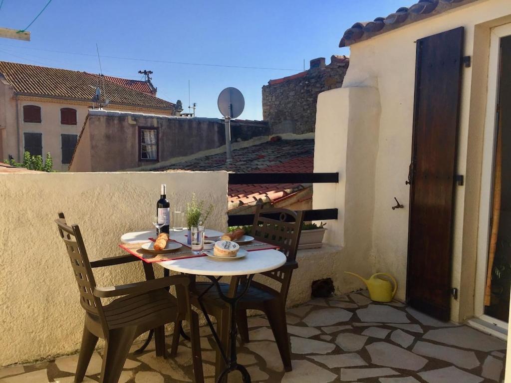 un patio avec une table et des chaises sur un balcon dans l'établissement Centre of Olonzac, 2 bedrooms & private sunny rooftop terrace, à Olonzac