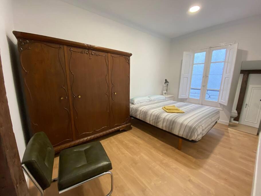 1 dormitorio con 1 cama y un gran armario de madera en Santander Jiménez Díaz 7B, en Santander