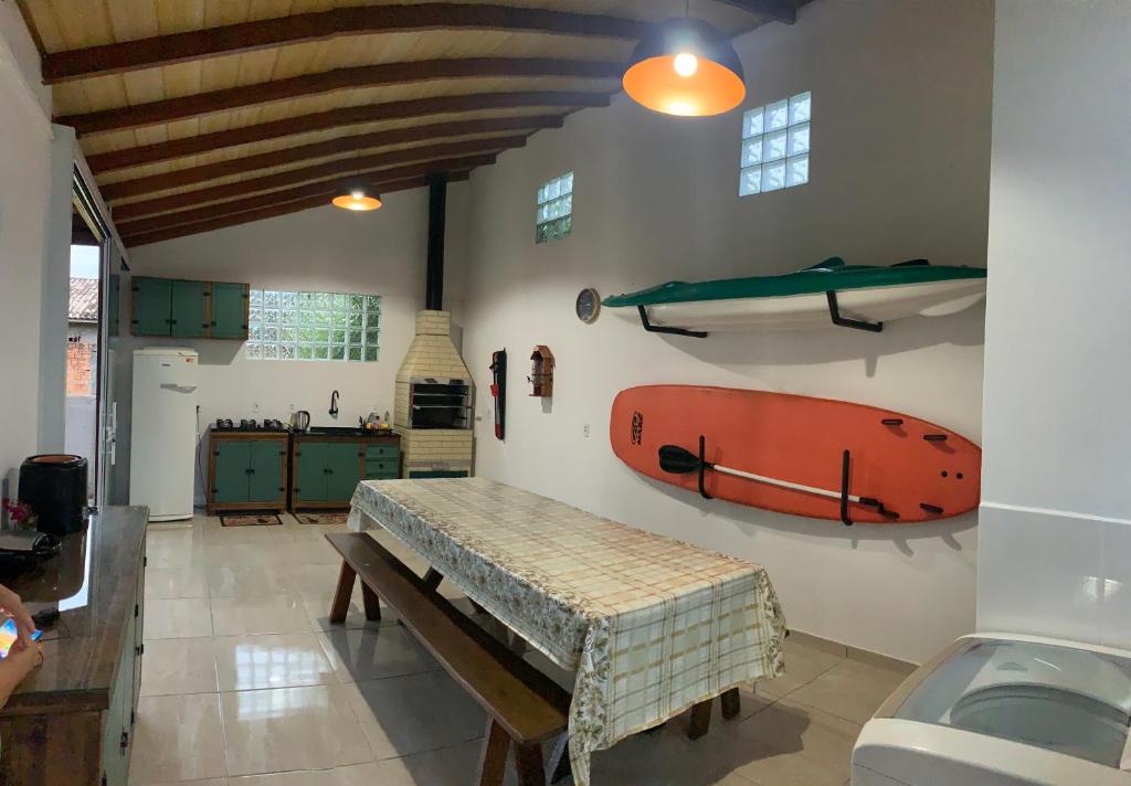 インビトゥバにあるCASA ACONCHEGANTE EM IBIRAQUERAのテーブルとカヤックが壁に掛けられた部屋