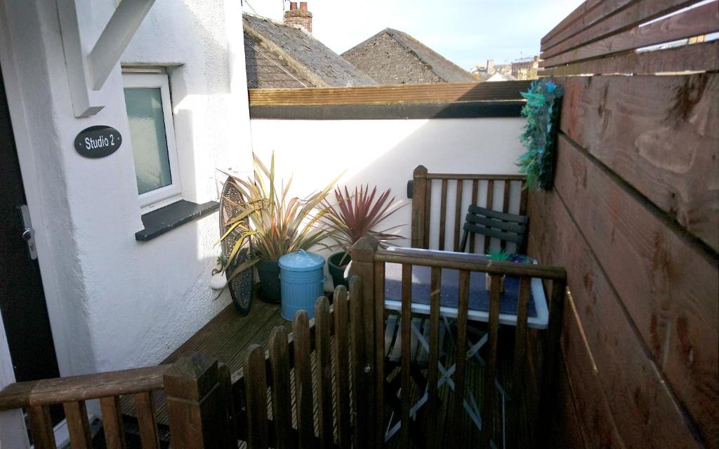 a balcony with two wooden benches and a window at Studio 2 in Newquay