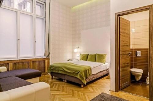 a bedroom with a bed and a bathroom with a toilet at The Cream in Budapest