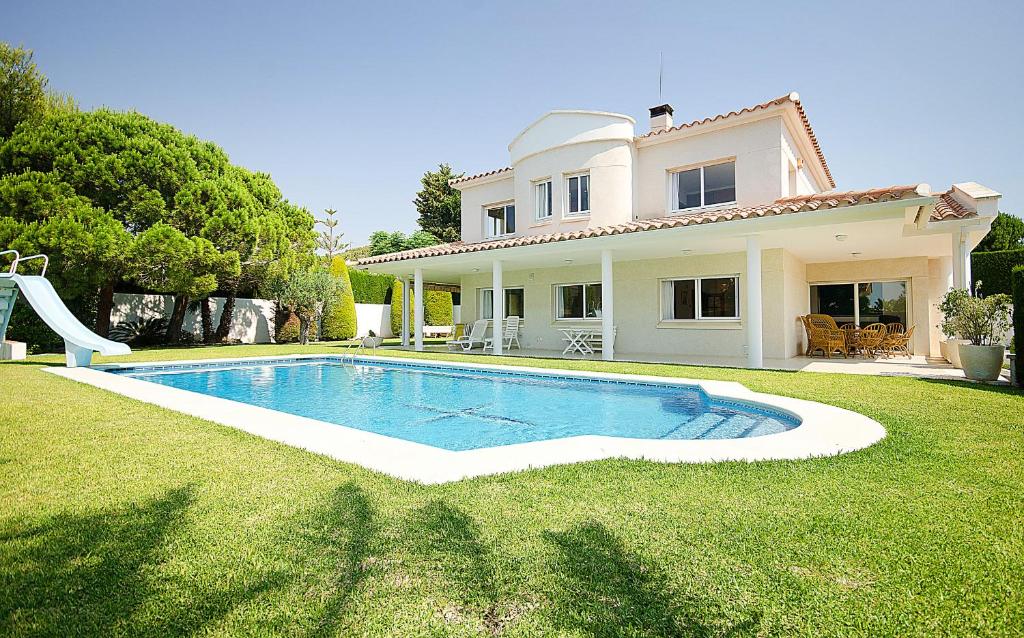 een huis met een zwembad in de tuin bij R11 Casa Blanca con gran jardin y piscina in Calafell
