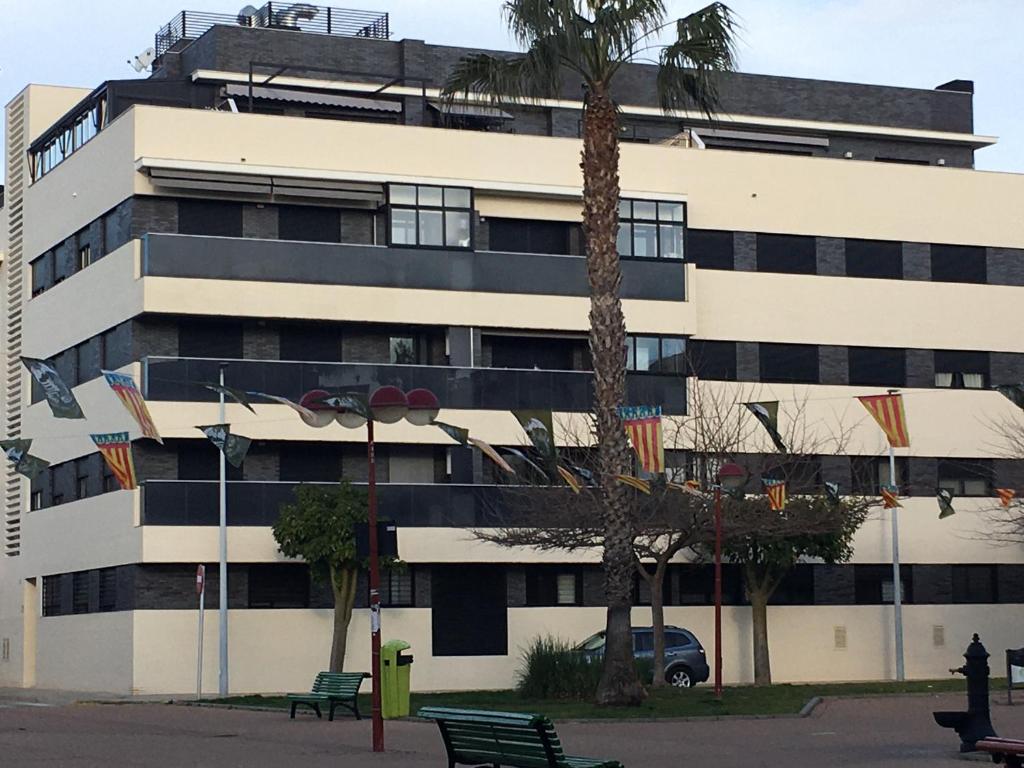 un edificio con una palmera delante de él en Modern & sunny apartment near Valencia, en Paiporta