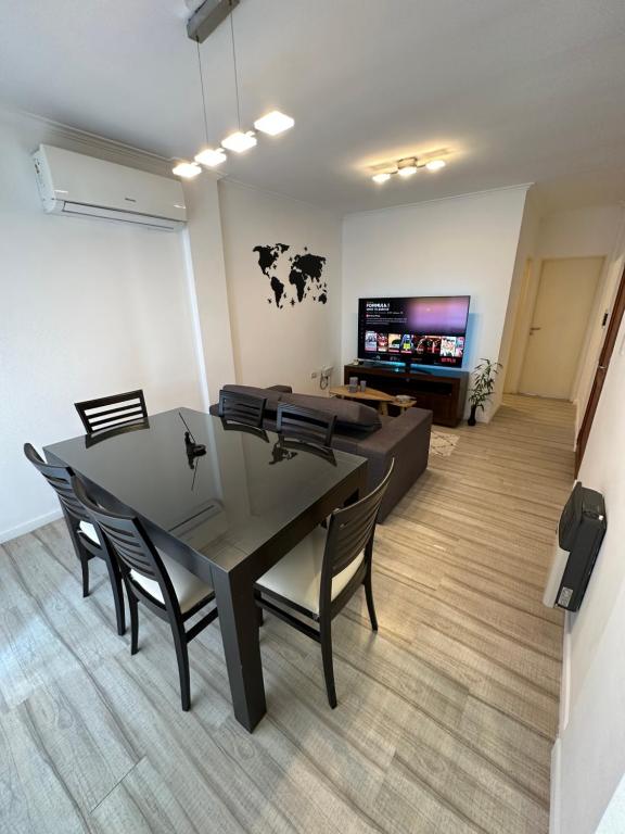 une salle à manger avec une table, des chaises et une télévision dans l'établissement Departamento temporal con cochera, à Santa Fe