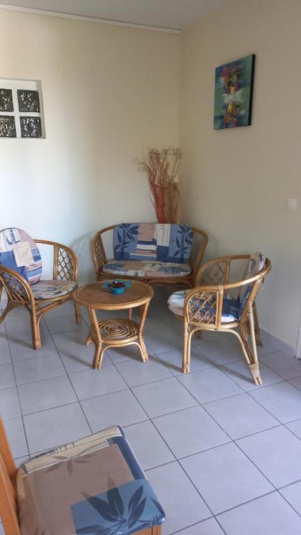 uma sala de estar com três cadeiras e um sofá em Charmant petit T2 dans maison em Vieux Bourg