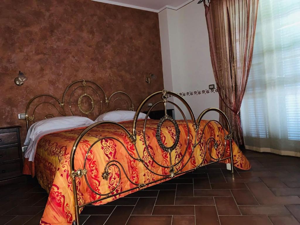 1 dormitorio con 1 cama con manta roja y amarilla en 8380 Agriturismo L'Oleandro, en Montemerano