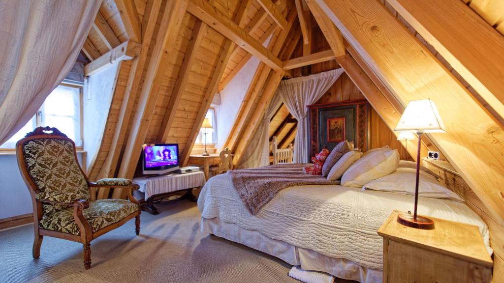 - une chambre avec un lit et une chaise dans l'établissement Remparts de Riquewihr - Le Colombier, à Riquewihr
