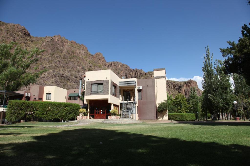 a house with a mountain in the background at Cabañas Del Sol in Valle Grande