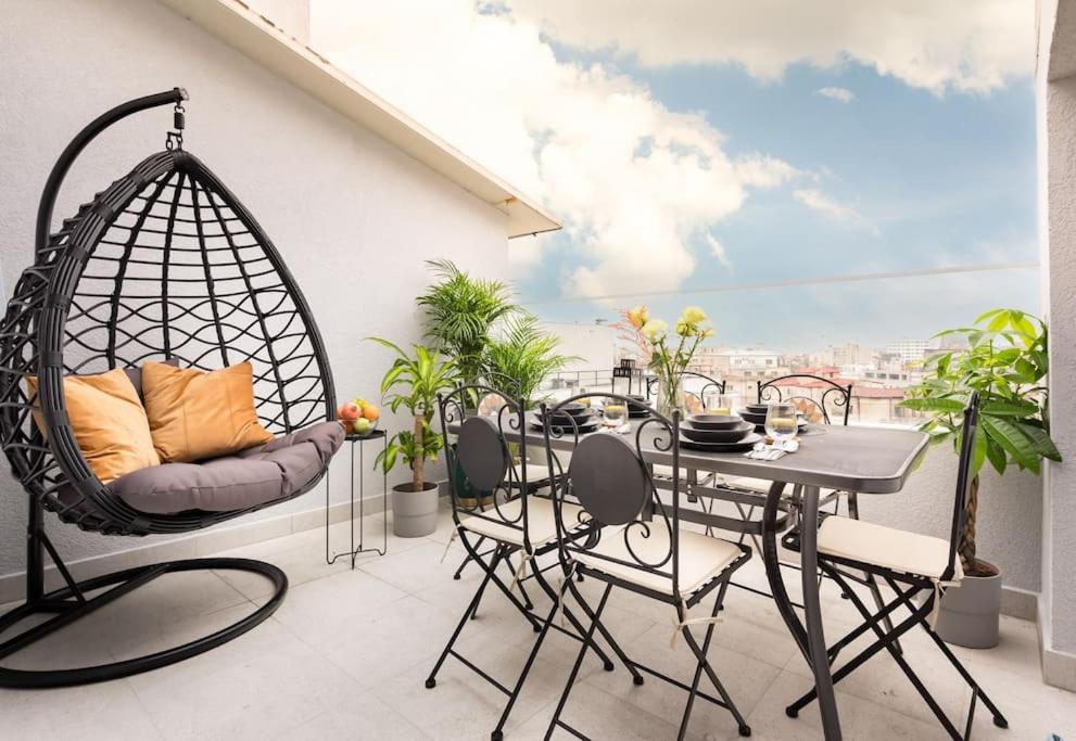 a patio with a swing chair and a table on a balcony at Spectacular Apartment - 4BR-Terrace - Piata Romana in Bucharest