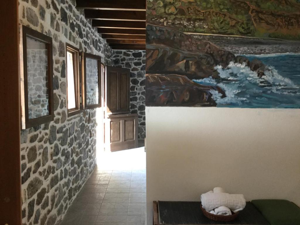Mandrákion的住宿－Volcano View Nisyros，走廊上墙上有画作和桌子