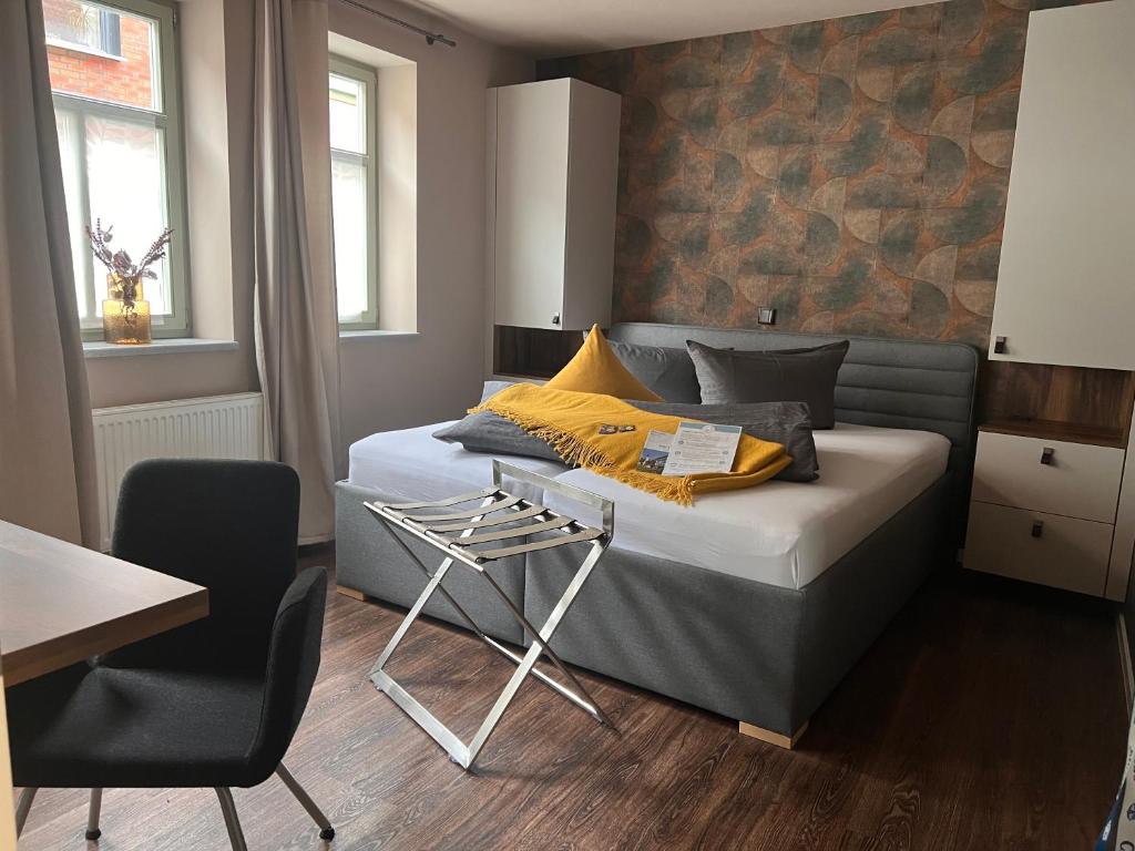 1 dormitorio con 1 cama, 1 mesa y 1 silla en Altstadtpension am Dom, en Erfurt